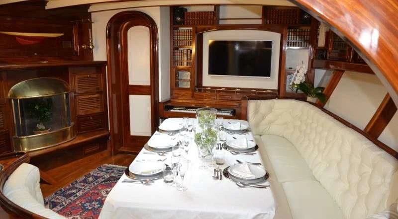 a dining table with a white tablecloth and a television aboard WHITEFIN Yacht for Sale