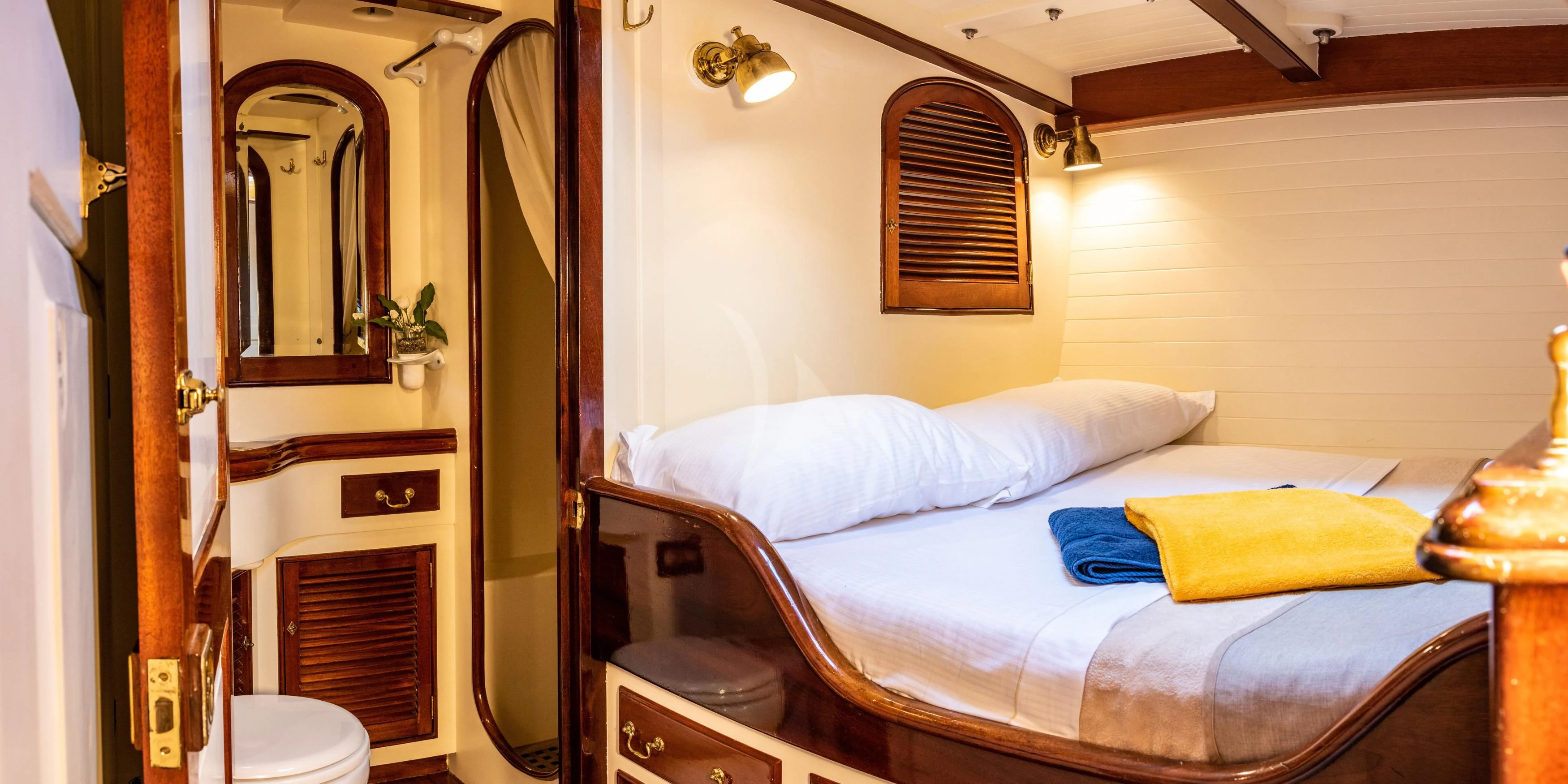 a bedroom with a bed and a mirror aboard WHITEFIN Yacht for Sale