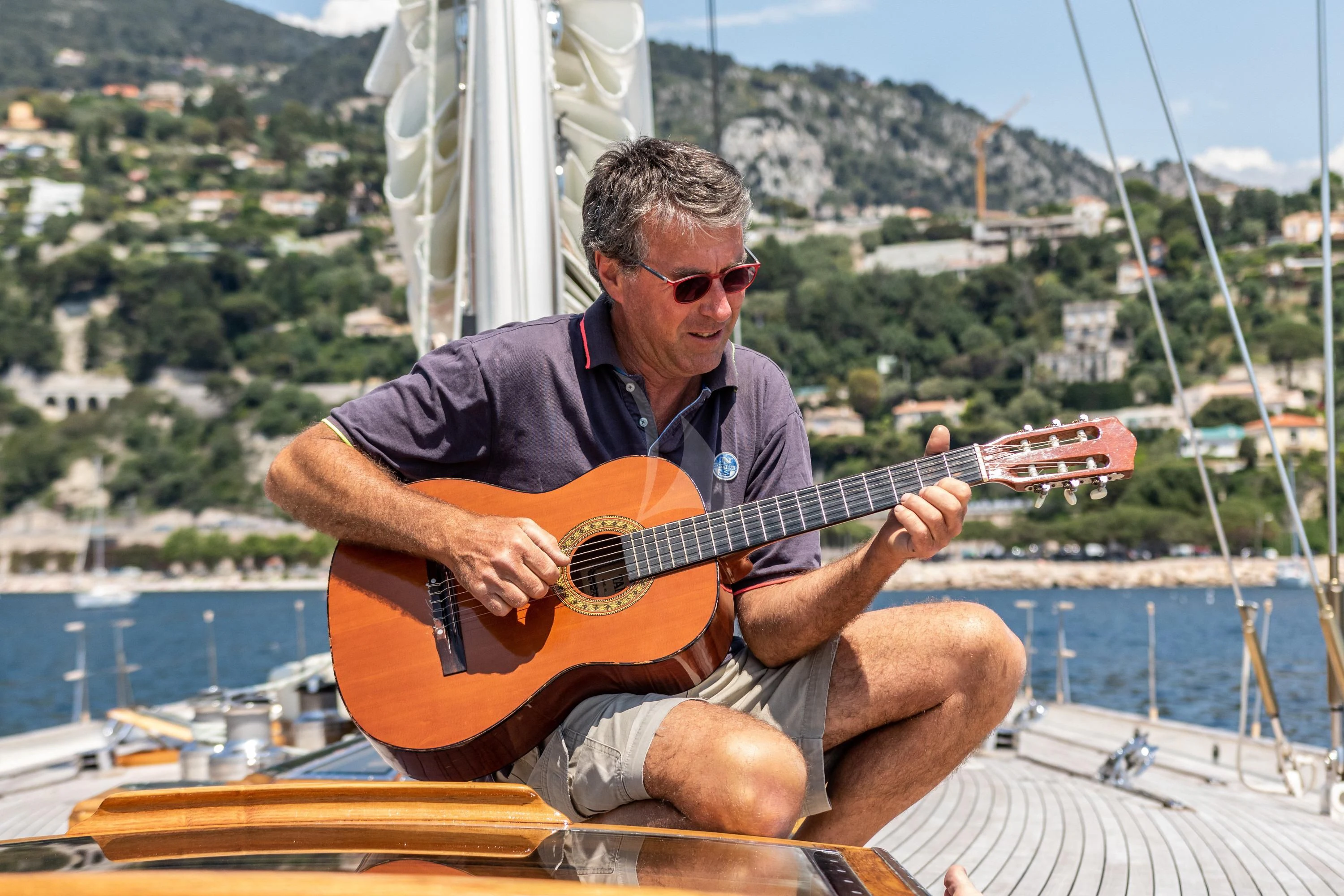 a man playing a guitar on a boat aboard WHITEFIN Yacht for Sale