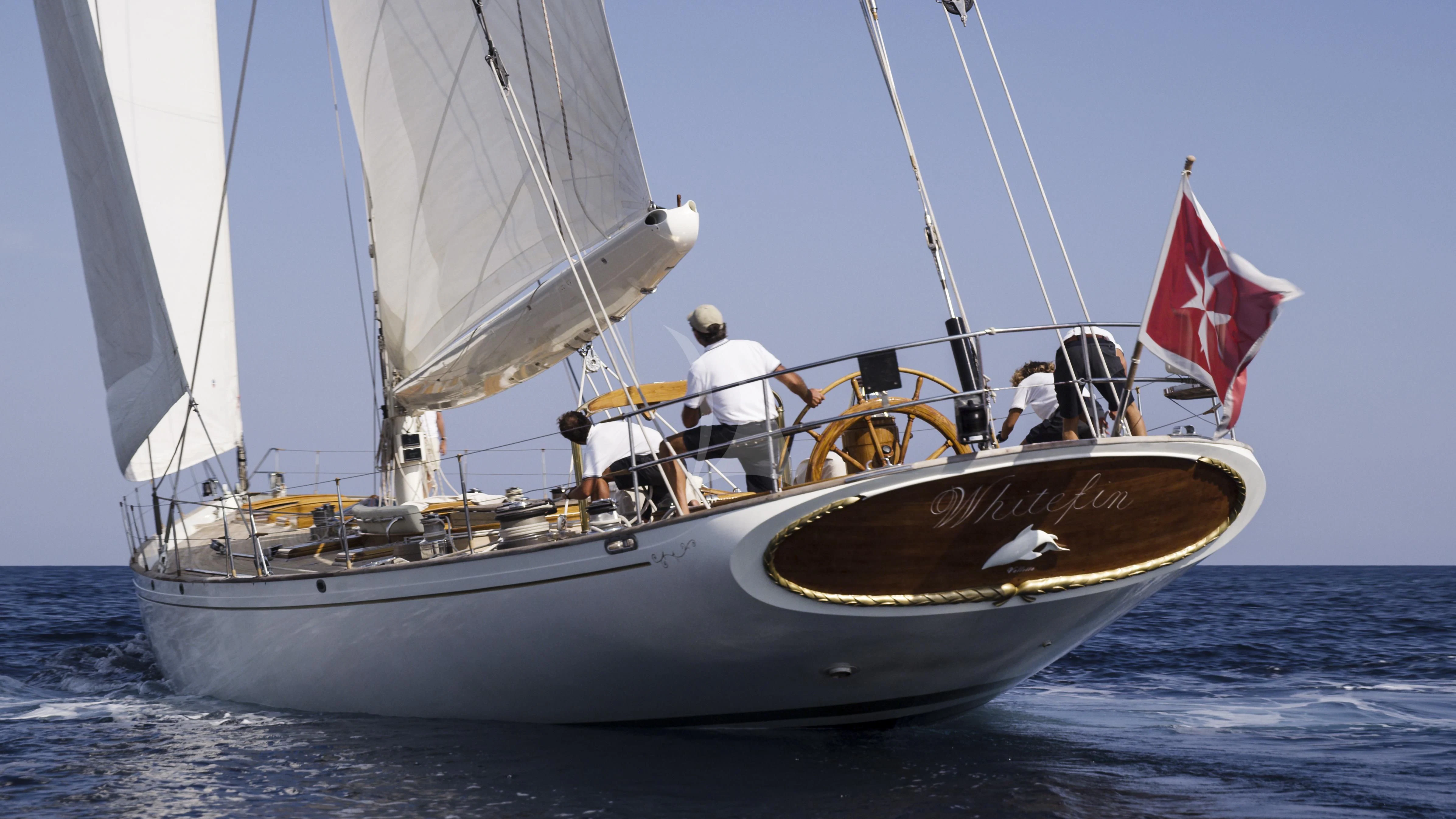 a sailboat with a flag on the front aboard WHITEFIN Yacht for Sale