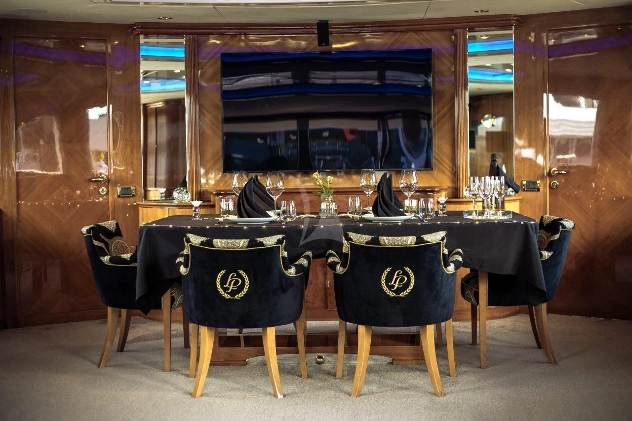 a table set with chairs and a bar aboard LADY PAMELA Yacht for Sale