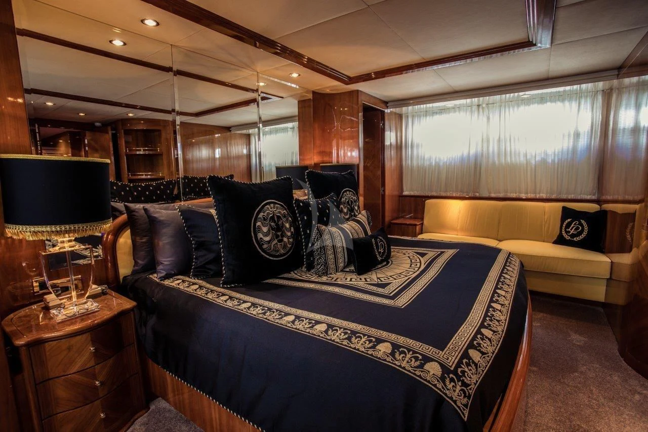 a bed with a couch and a table aboard LADY PAMELA Yacht for Sale