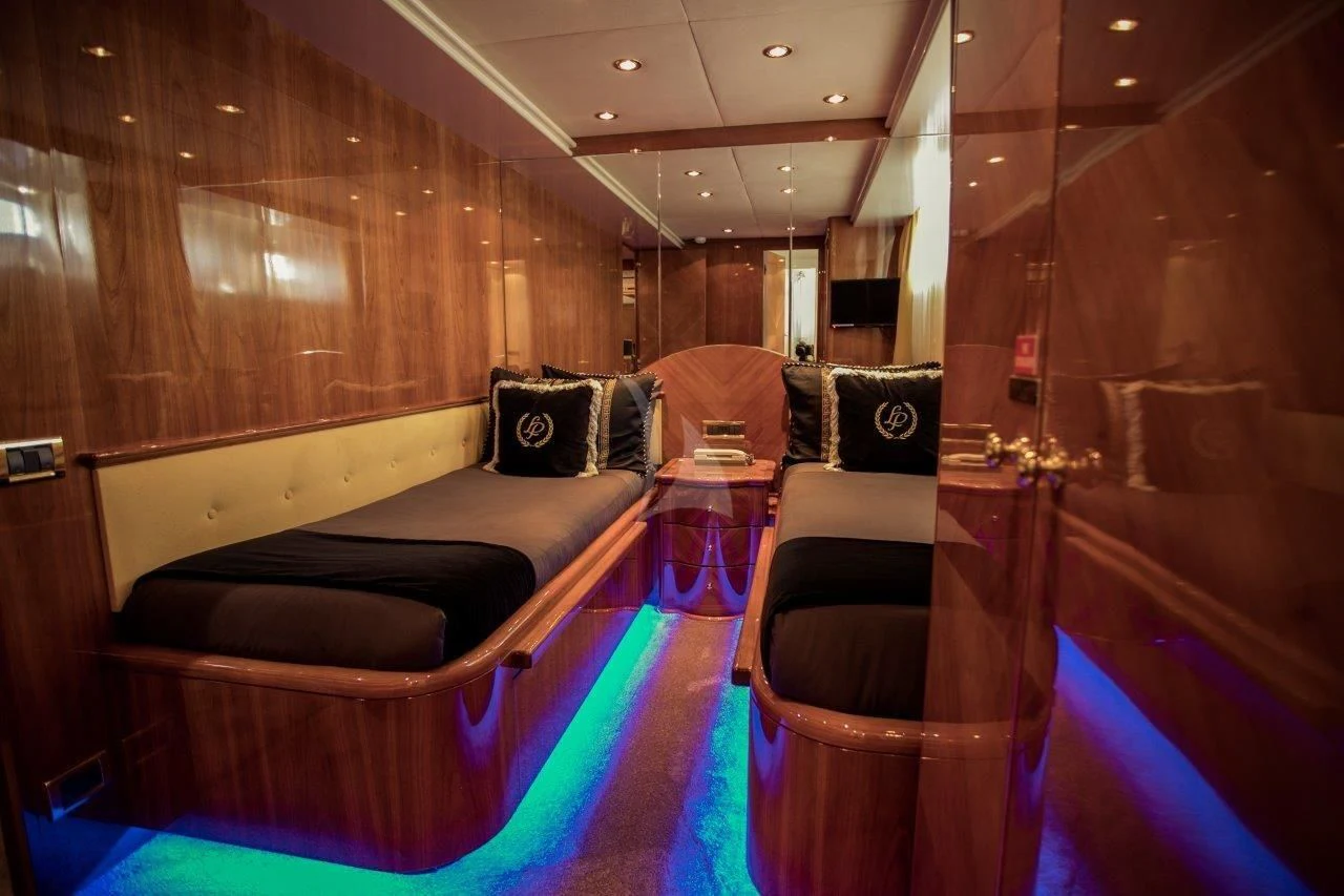 a room with a bed and a chair aboard LADY PAMELA Yacht for Sale