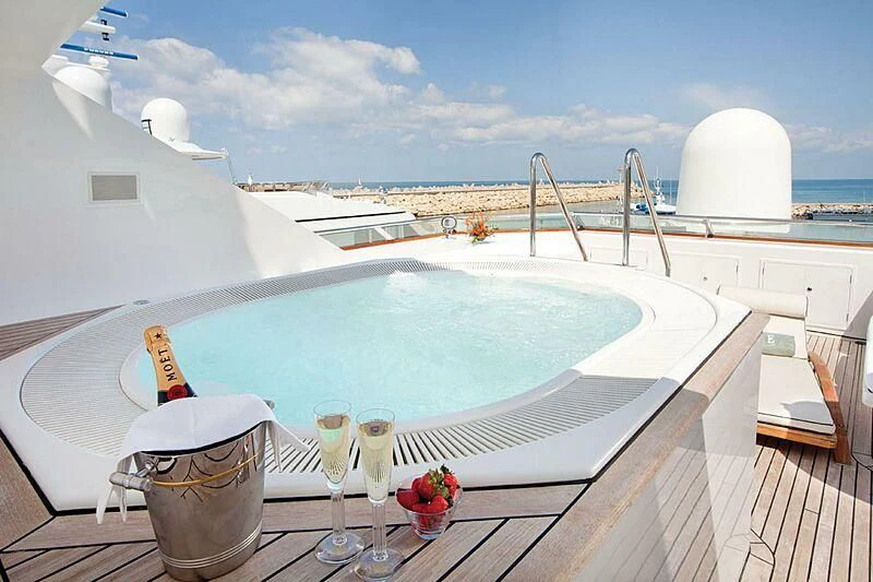 a pool with a table and chairs aboard LORETTA Yacht for Sale