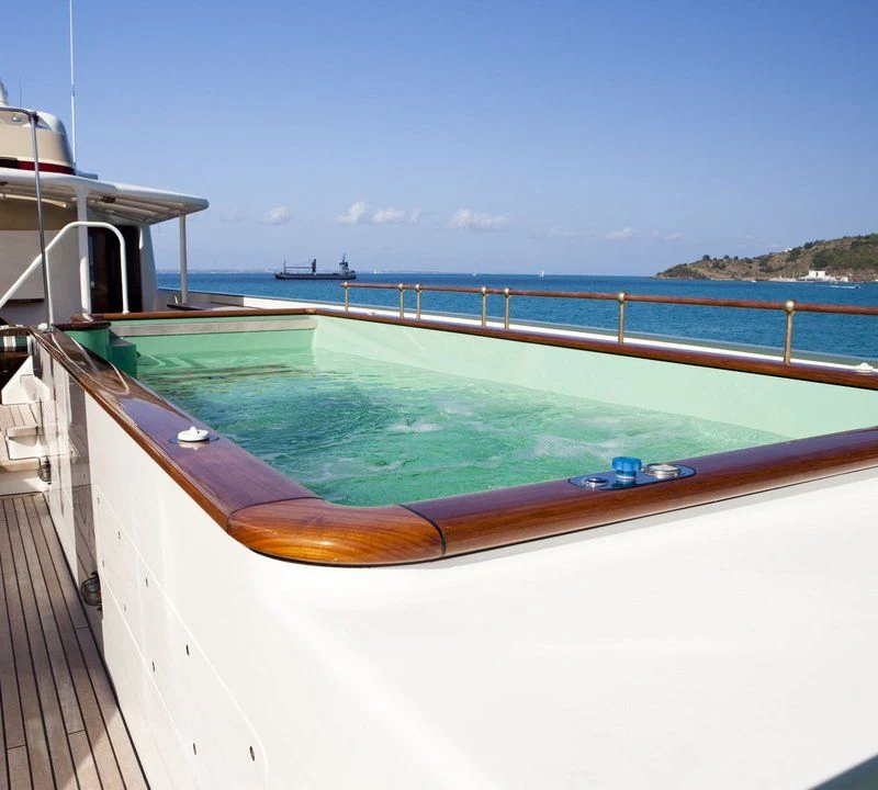 a large pool with a deck and a deck and a beach aboard STEEL Yacht for Sale