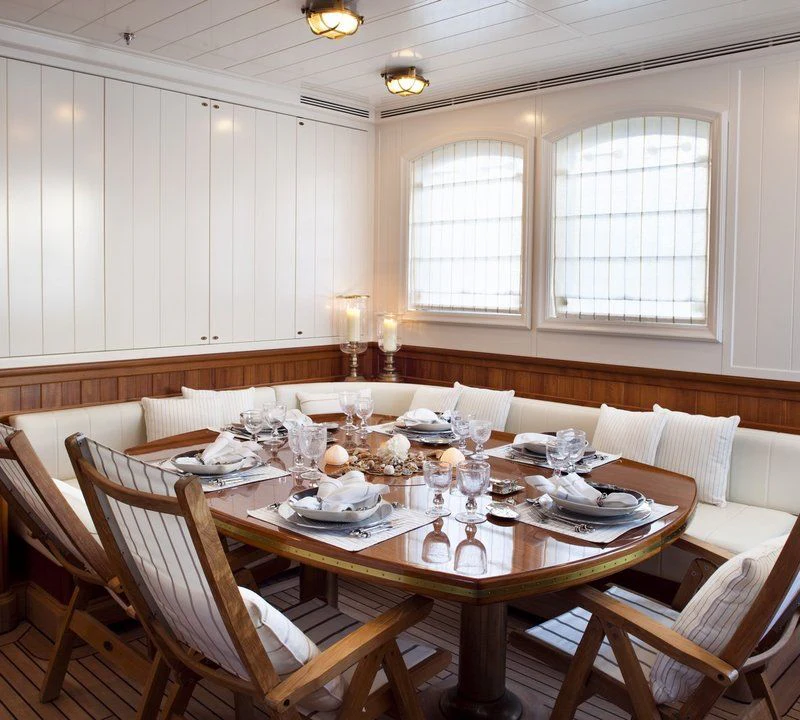 a dining room with a table set aboard STEEL Yacht for Sale