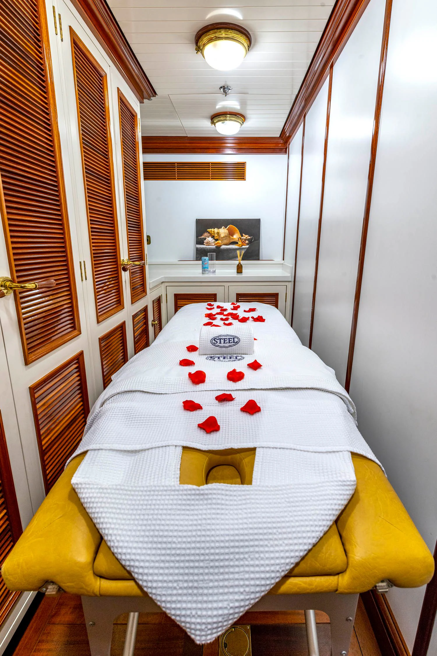 a white and yellow bed with red pillows and a yellow bow tie aboard STEEL Yacht for Sale