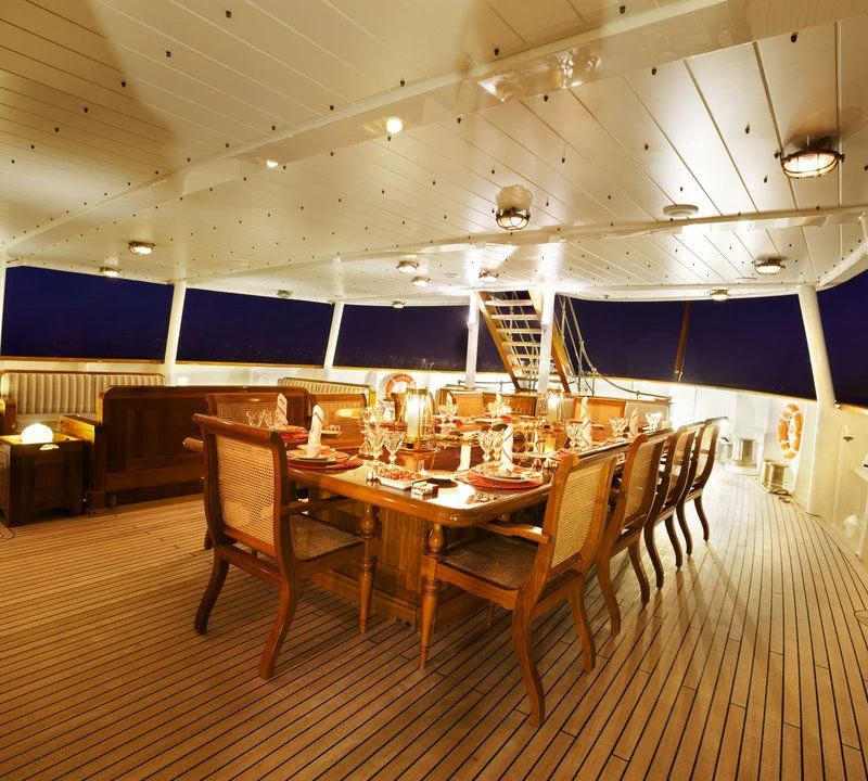 a large room with tables and chairs aboard STEEL Yacht for Sale