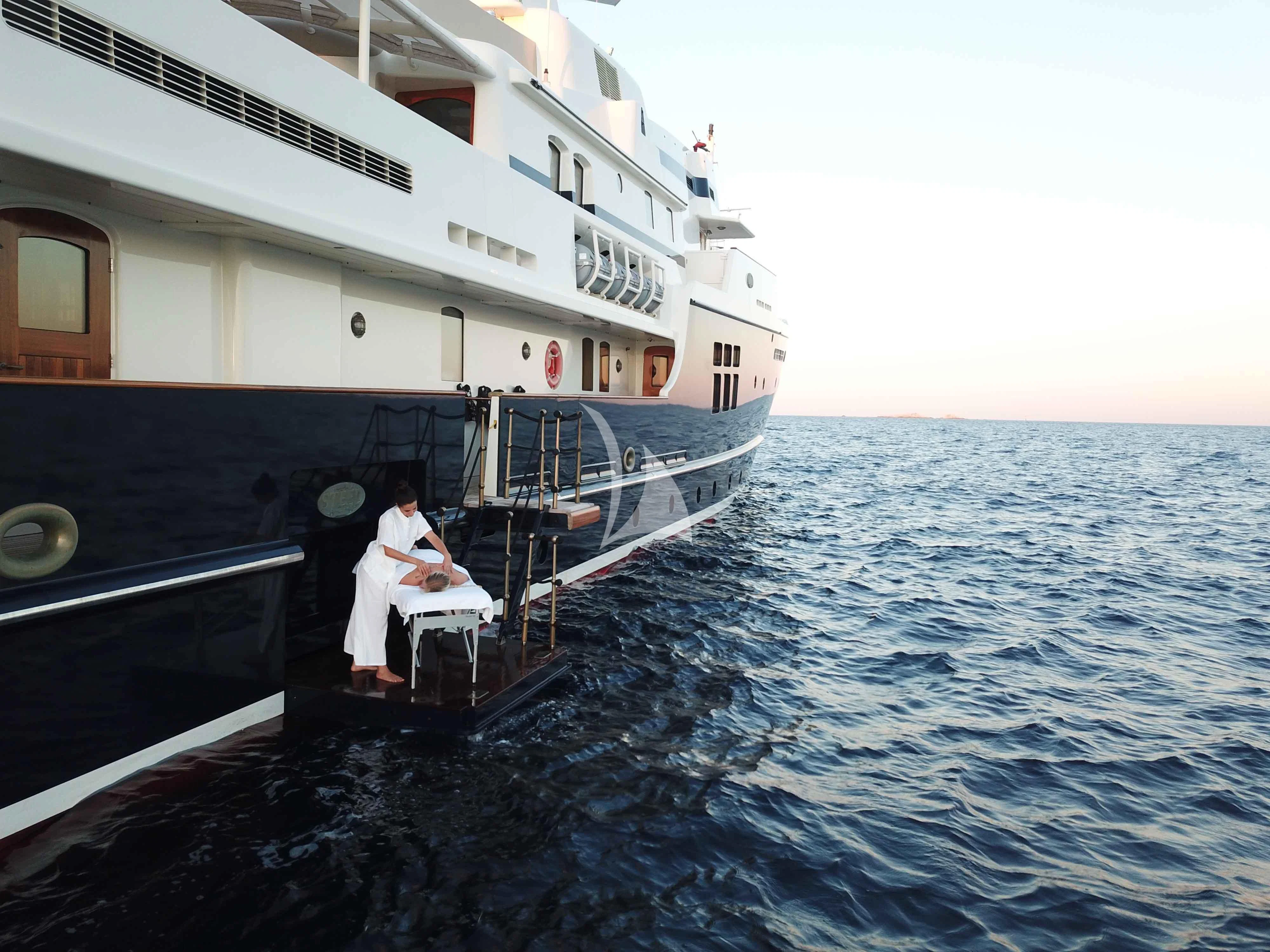 a man and woman sitting on a boat in the water aboard STEEL Yacht for Sale