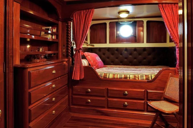 a room with a bed and a mirror aboard STEEL Yacht for Sale