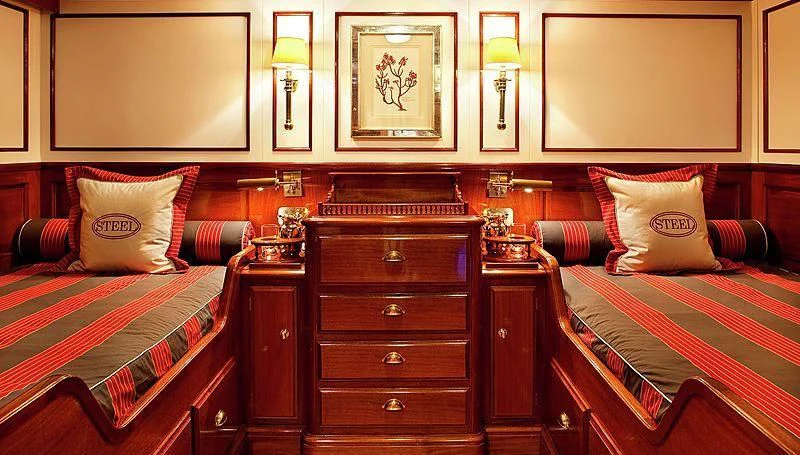 a room with a bed and a dresser aboard STEEL Yacht for Sale