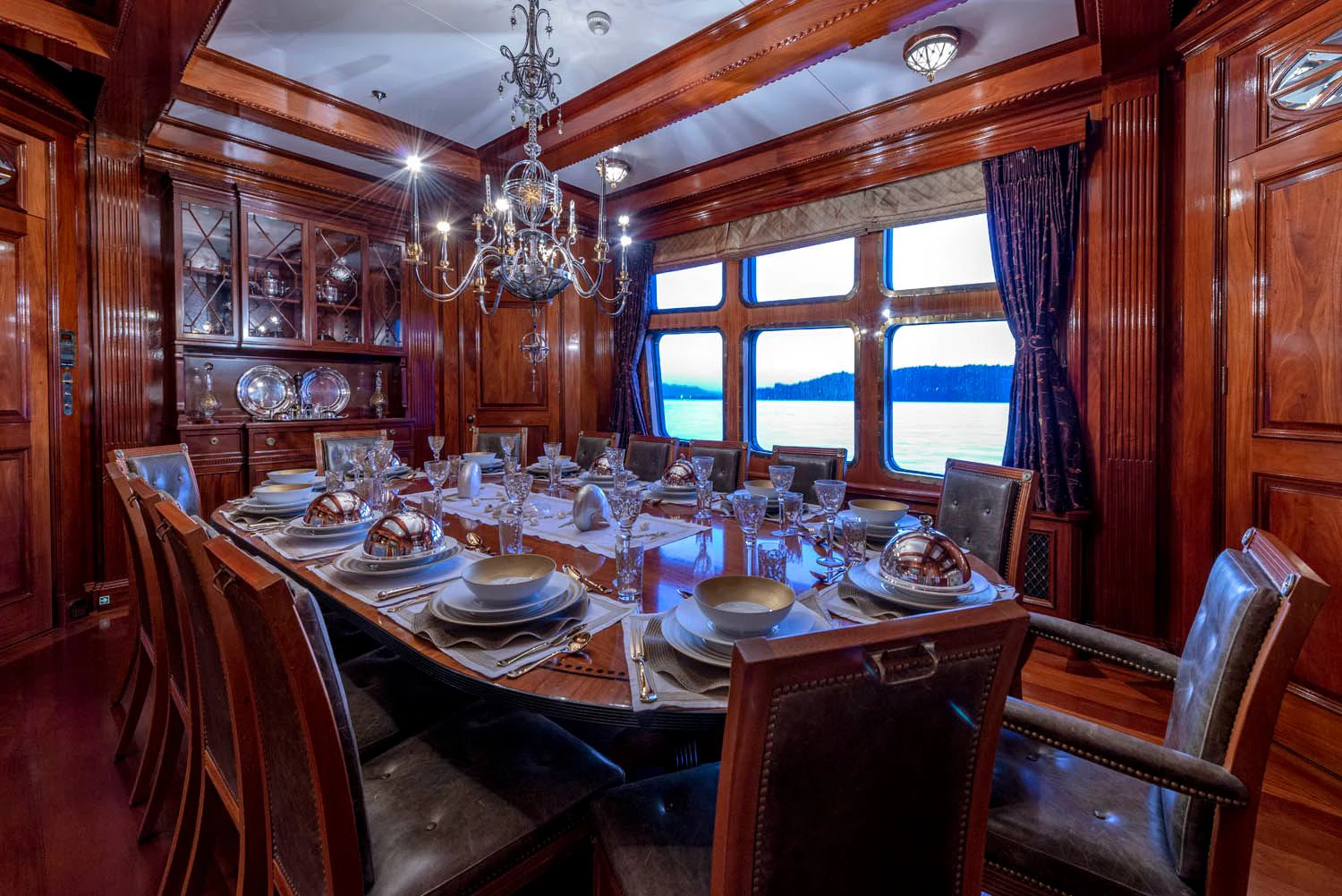a dining room with a chandelier aboard STEEL Yacht for Sale