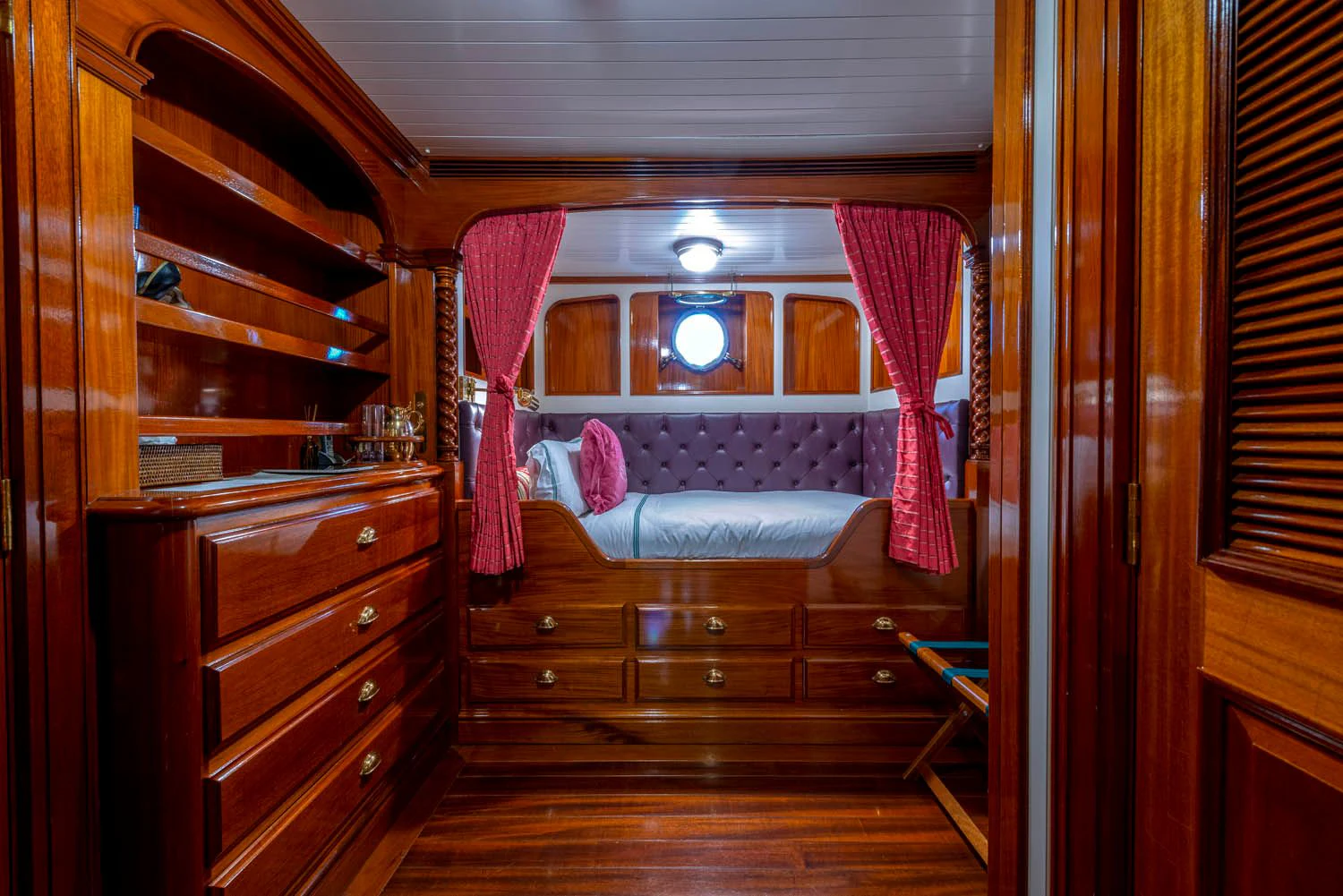 a bedroom with a bed and a dresser aboard STEEL Yacht for Sale