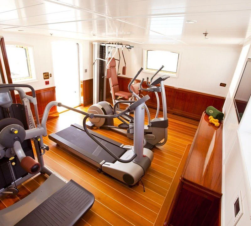 a room with a gym and a large window aboard STEEL Yacht for Sale