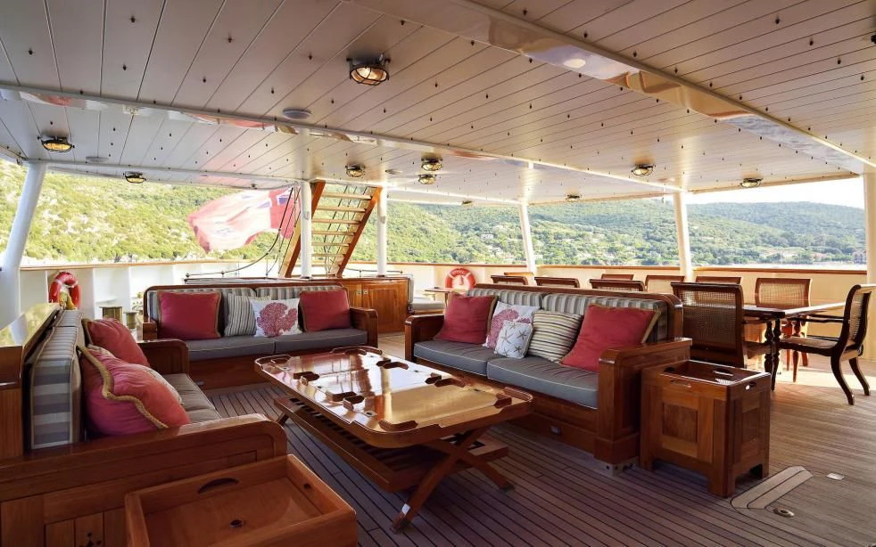 a living room with a couch and a table aboard STEEL Yacht for Sale