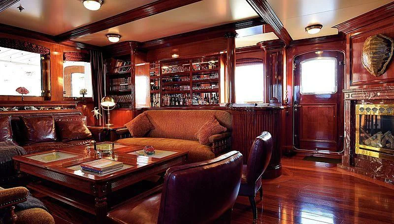 a living room with a wood paneled wall aboard STEEL Yacht for Sale