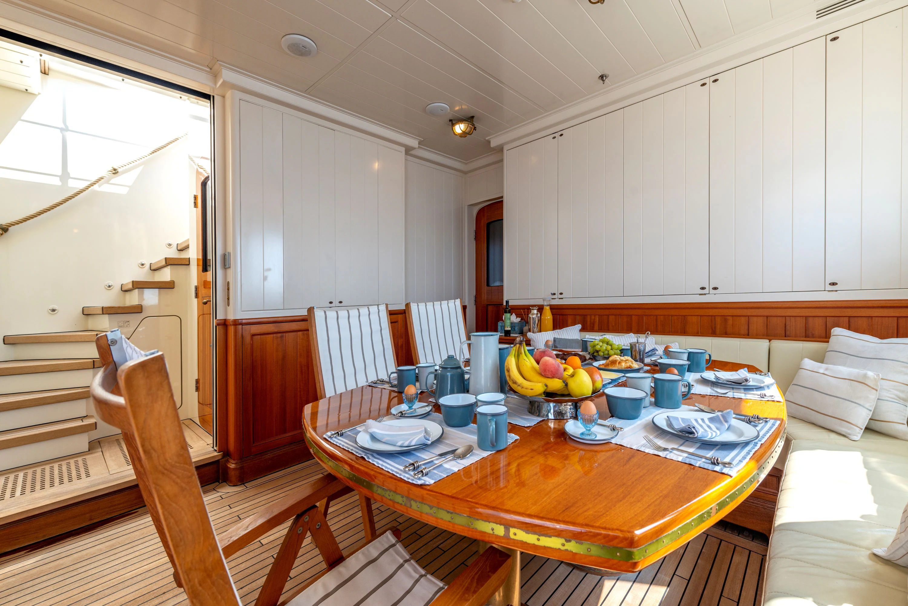 a kitchen with a table and chairs aboard STEEL Yacht for Sale