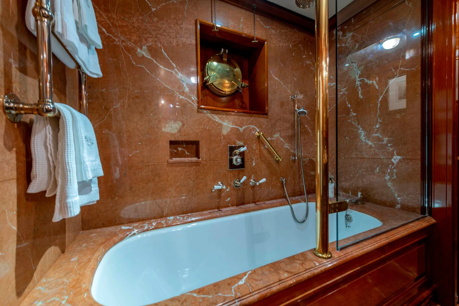 a bathroom with a bathtub and a mirror aboard STEEL Yacht for Sale
