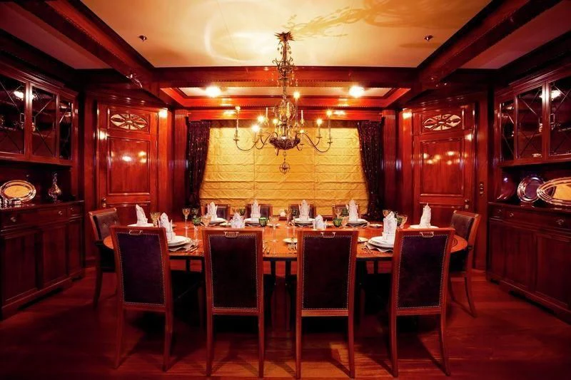 a dining room with a chandelier aboard STEEL Yacht for Sale
