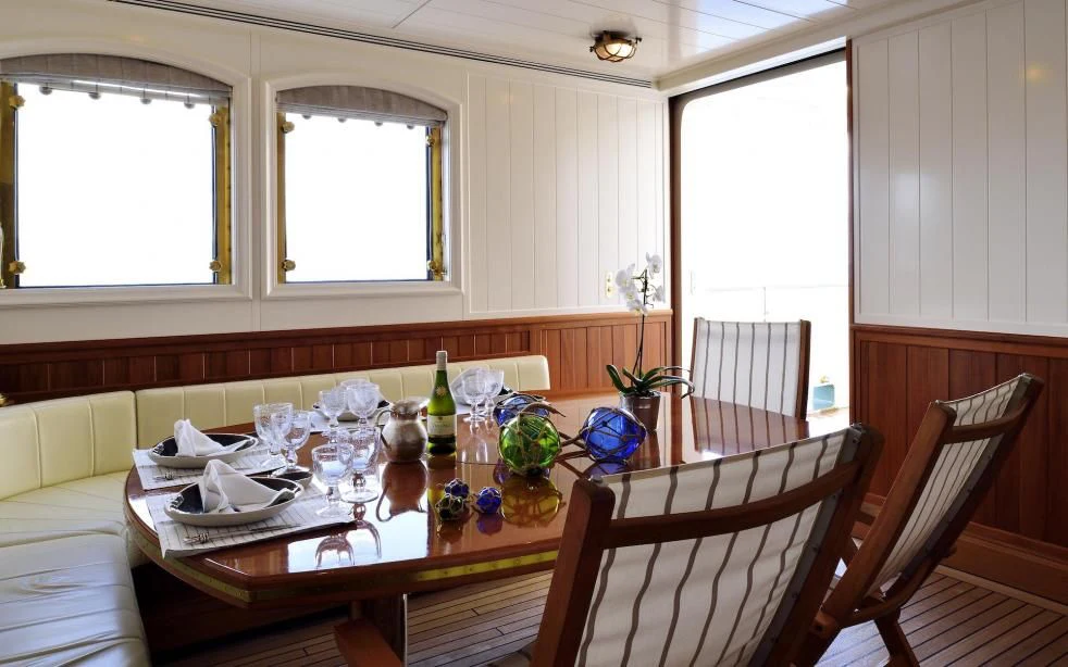 a dining table with glasses and food aboard STEEL Yacht for Sale