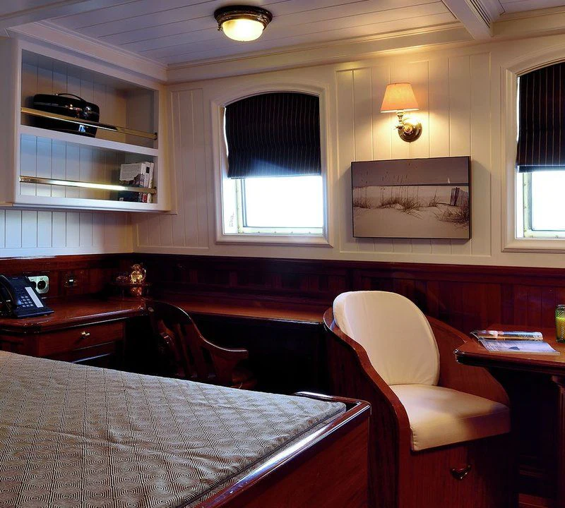 a room with a bed and a chair aboard STEEL Yacht for Sale