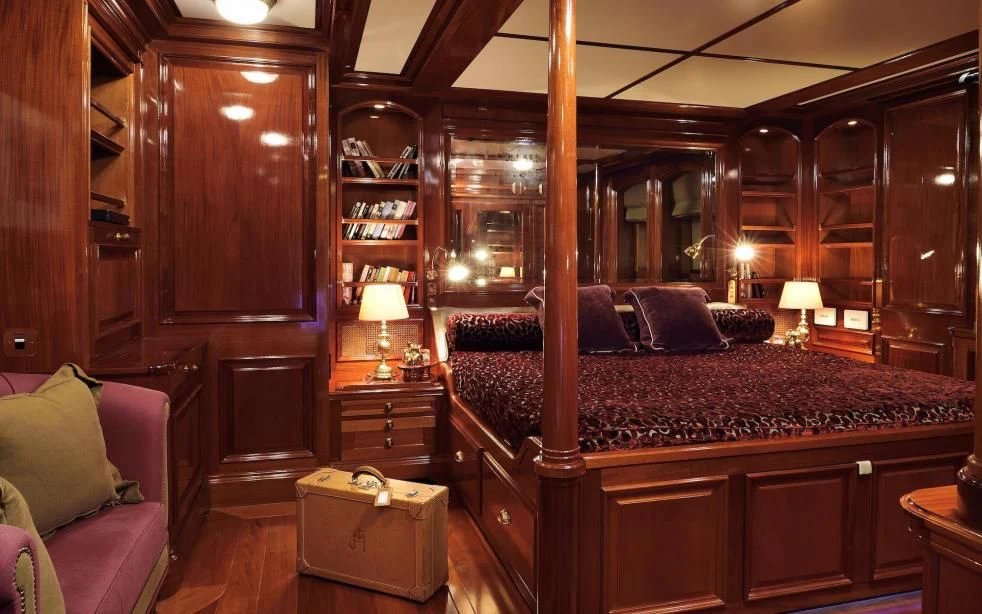 a bedroom with a bed and a bookcase aboard STEEL Yacht for Sale