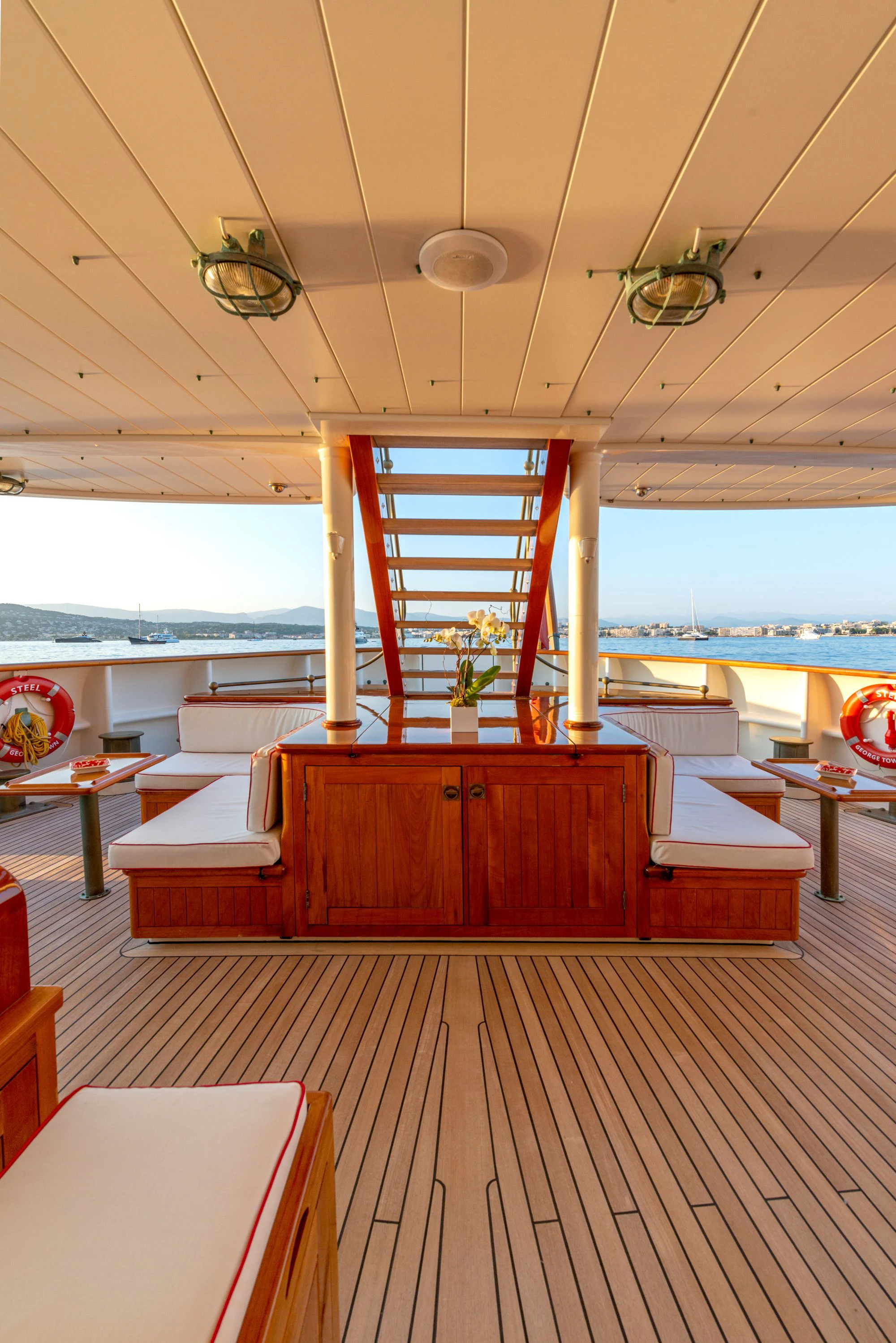 a room with a wood floor and a large window with a view of the water aboard STEEL Yacht for Sale
