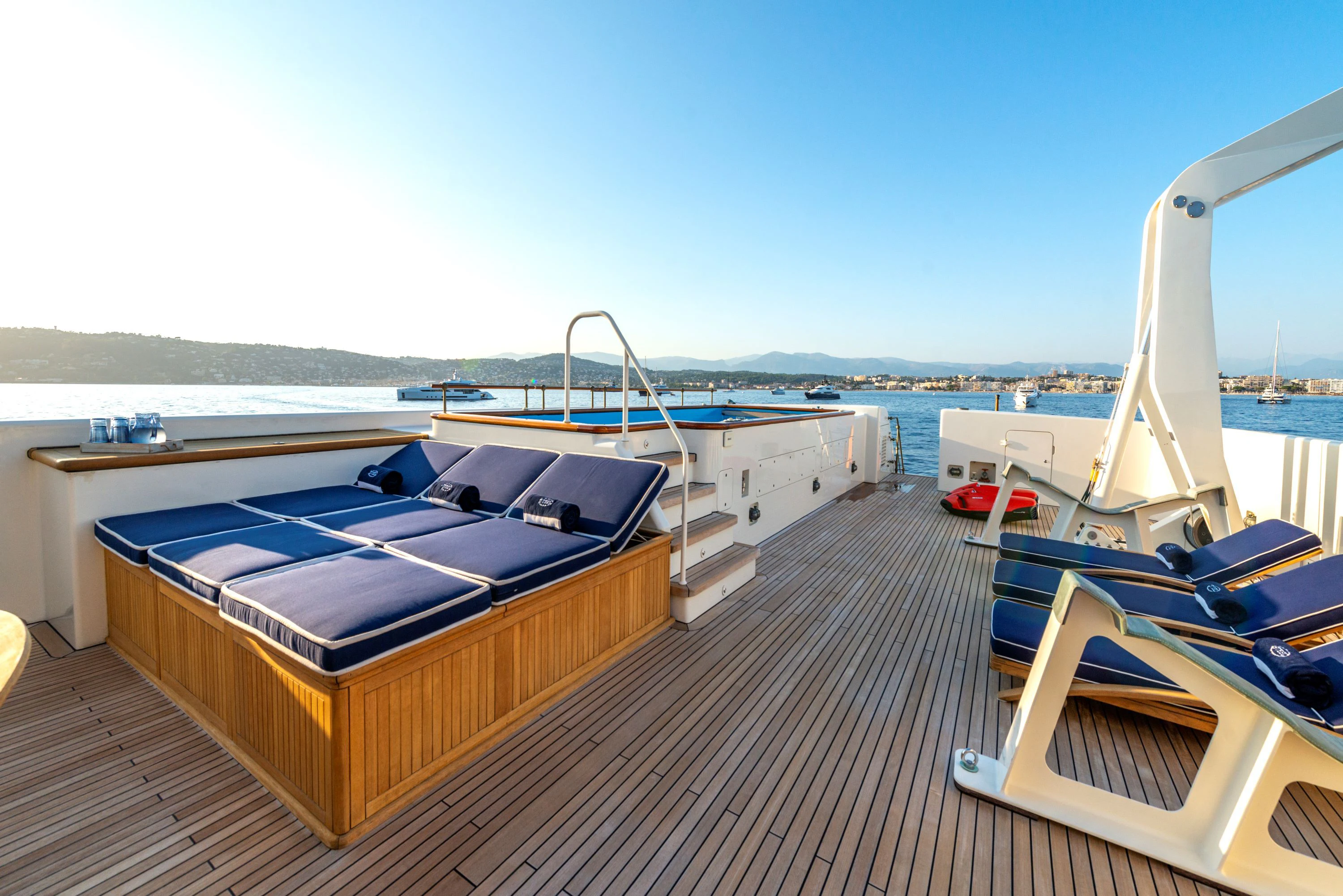 a deck with a boat and a deck with chairs on it aboard STEEL Yacht for Sale