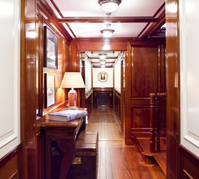 a room with wood walls and a clock on the wall aboard STEEL Yacht for Sale