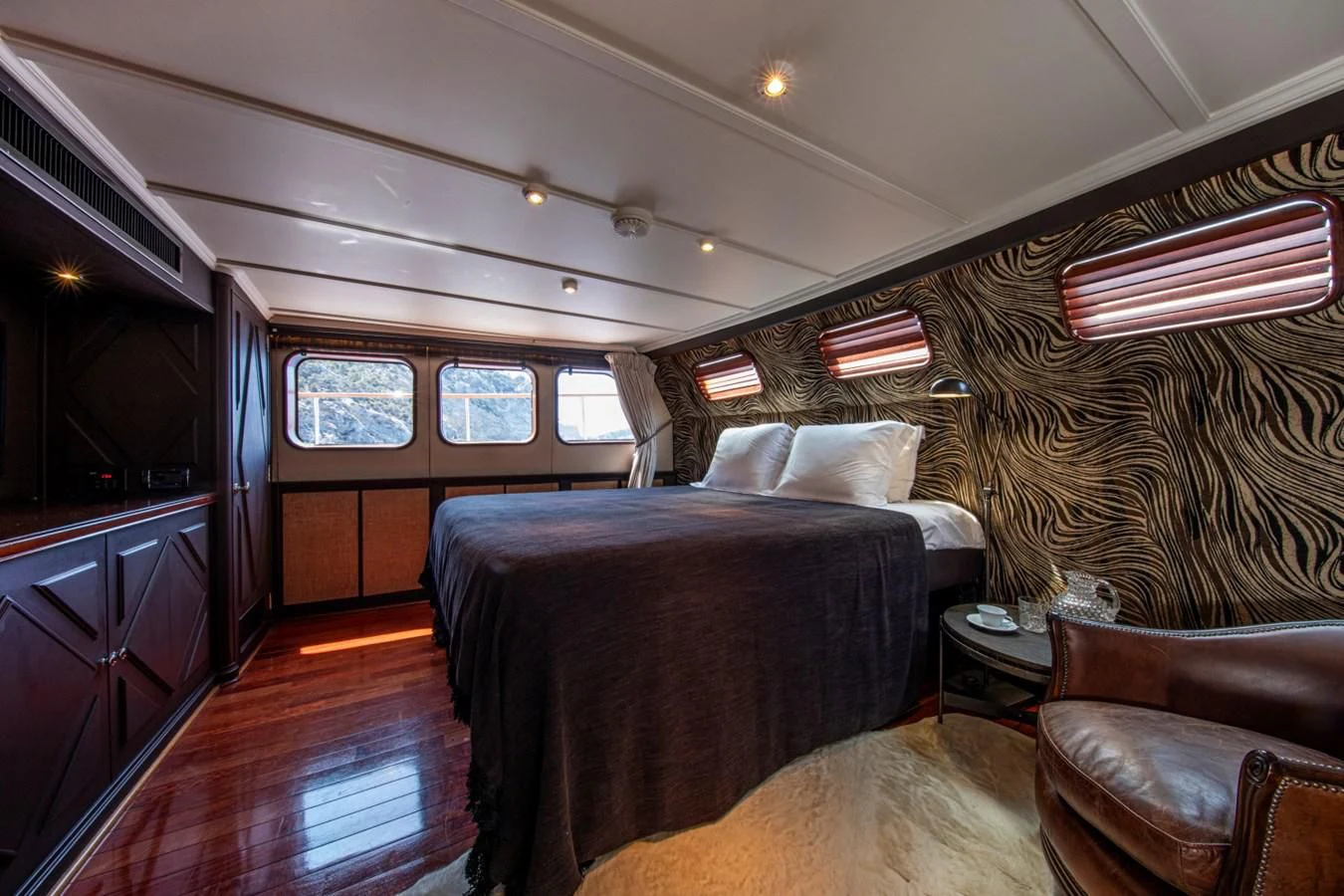 a bedroom with a bed and a chair aboard SANTA MARIA Yacht for Sale
