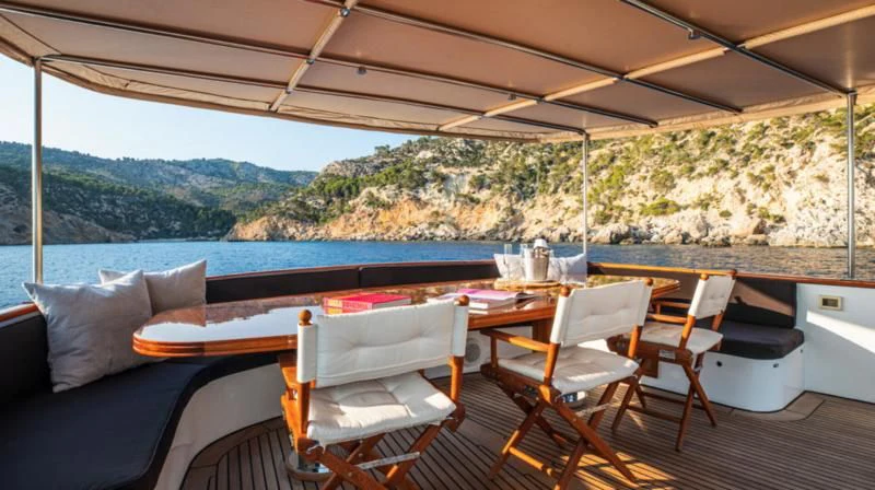 a deck with a table and chairs aboard SANTA MARIA Yacht for Sale