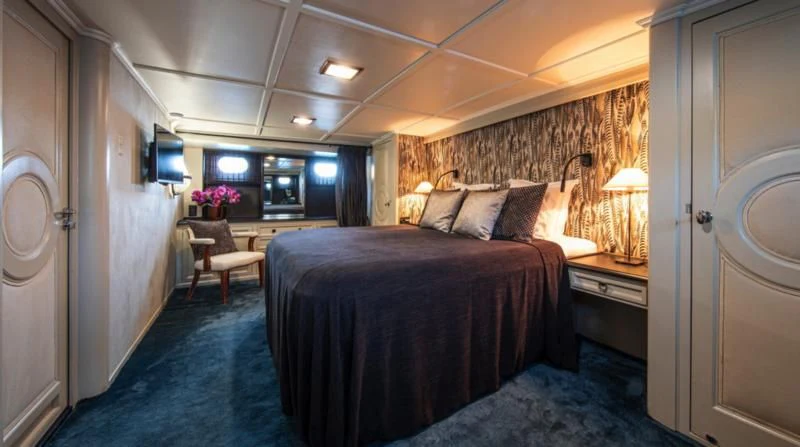 a bedroom with a bed and a television on the wall aboard SANTA MARIA Yacht for Sale
