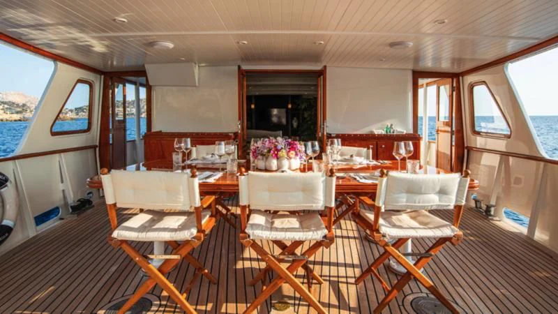 a room with tables and chairs aboard SANTA MARIA Yacht for Sale