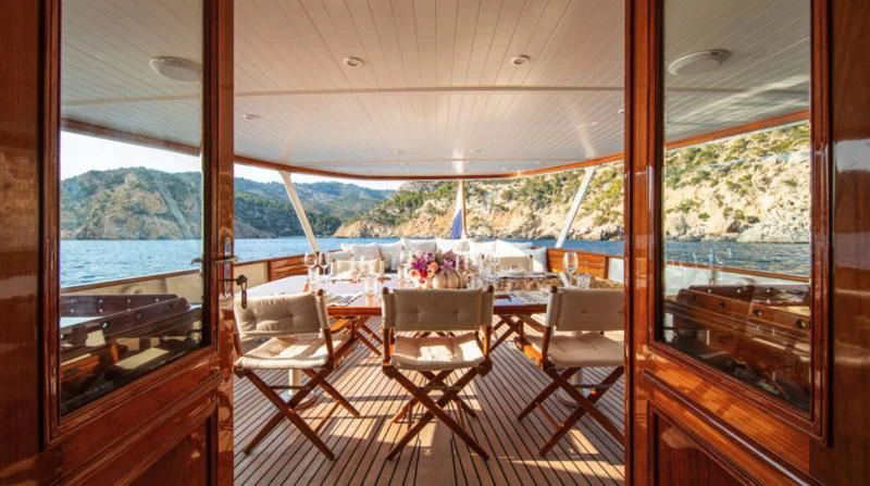 a room with a table chairs and a view of the water aboard SANTA MARIA Yacht for Sale