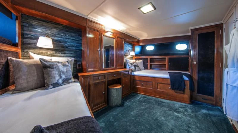 a bedroom with a bed and a desk aboard SANTA MARIA Yacht for Sale