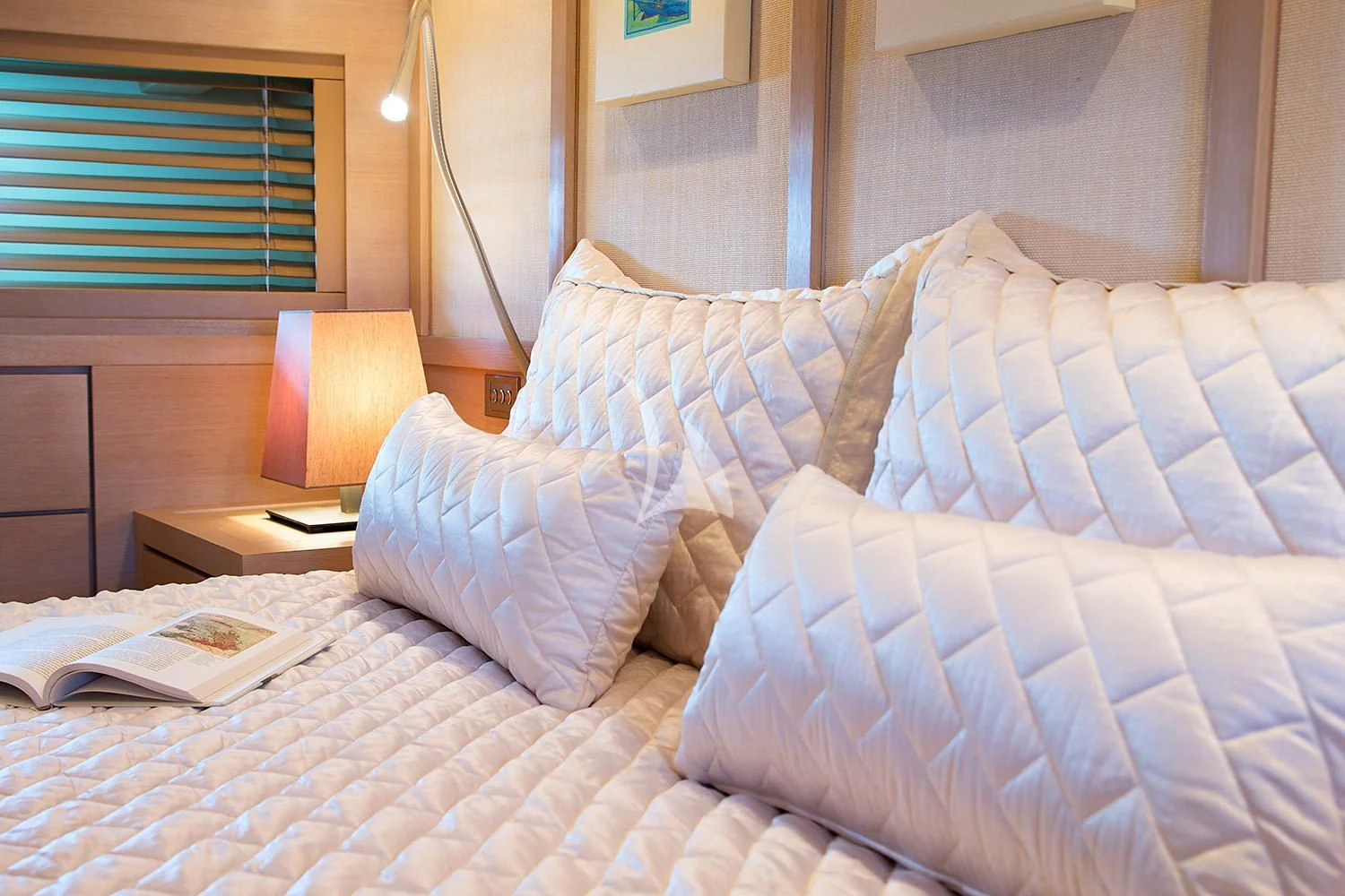 a bed with a checkered comforter and pillows aboard SUN ANEMOS Yacht for Charter