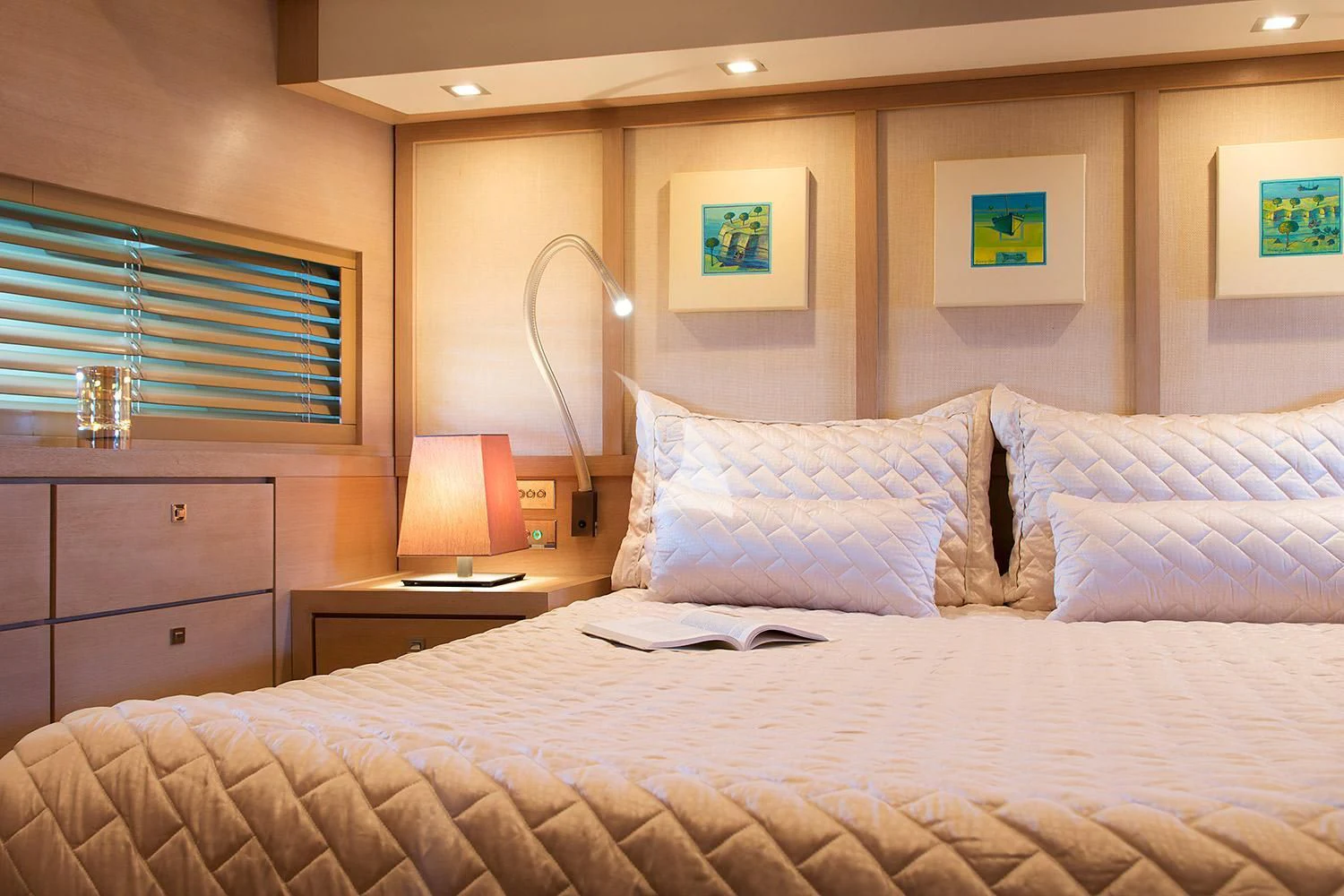a bed with a white comforter and a lamp on it aboard SUN ANEMOS Yacht for Charter