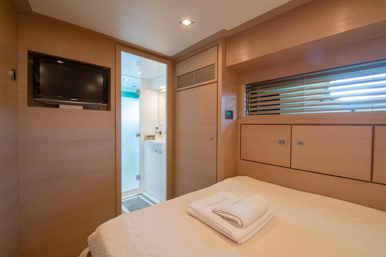 a hotel room with a bed and tv aboard SUN ANEMOS Yacht for Charter