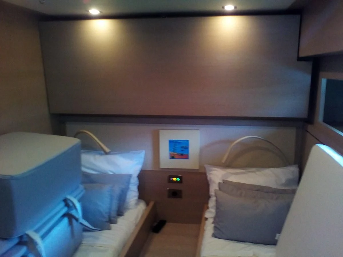 a room with a bed and a chair aboard SUN ANEMOS Yacht for Charter