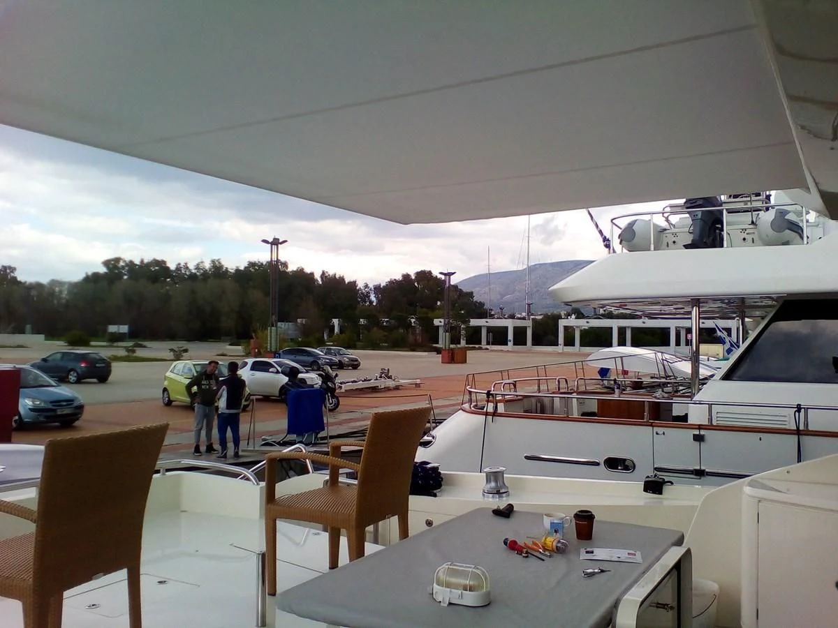 a group of people standing next to a boat on a dock aboard SUN ANEMOS Yacht for Charter