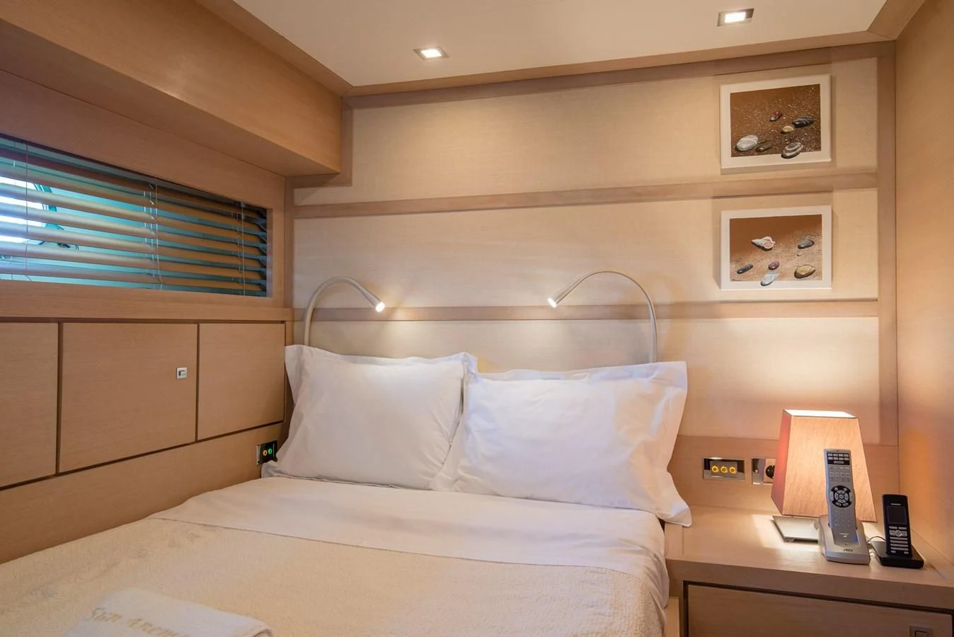 a bed with a phone on it aboard SUN ANEMOS Yacht for Charter