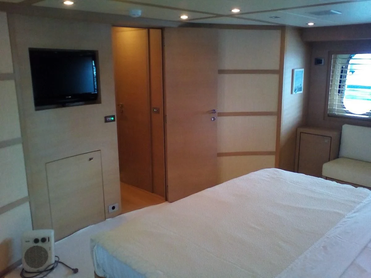 a room with a bed and a television aboard SUN ANEMOS Yacht for Charter