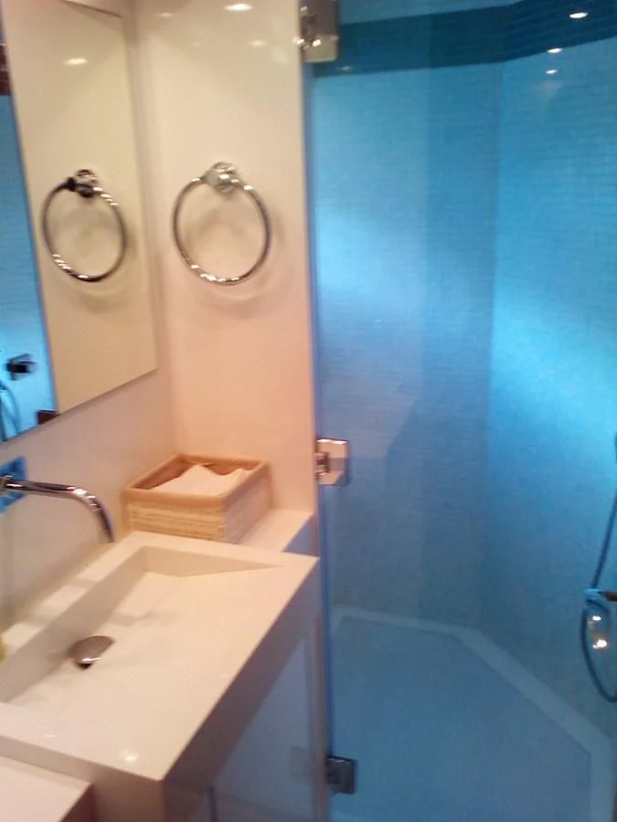 a bathroom with a blue shower curtain aboard SUN ANEMOS Yacht for Charter