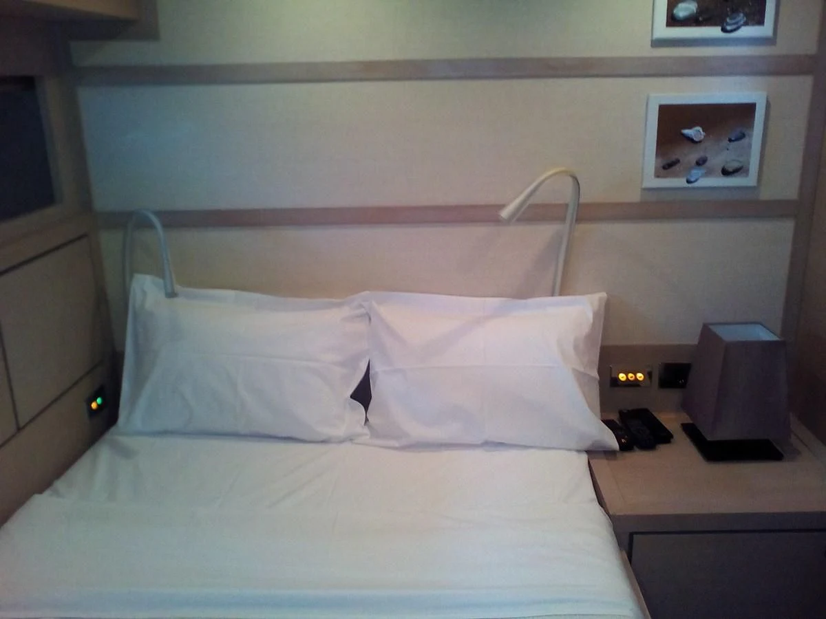 a bed with white sheets aboard SUN ANEMOS Yacht for Charter