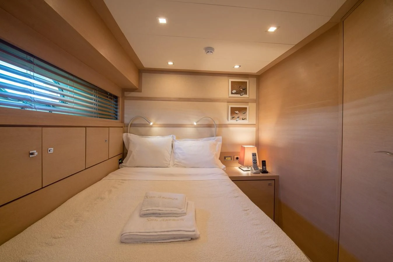 a bed with a white sheet and a white pillow on it aboard SUN ANEMOS Yacht for Charter