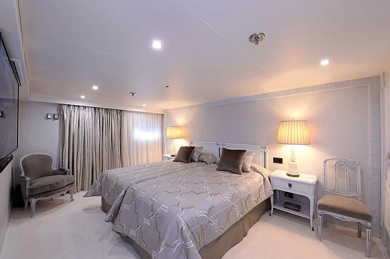 a bedroom with a bed and a chair aboard LADY SARYA Yacht for Sale