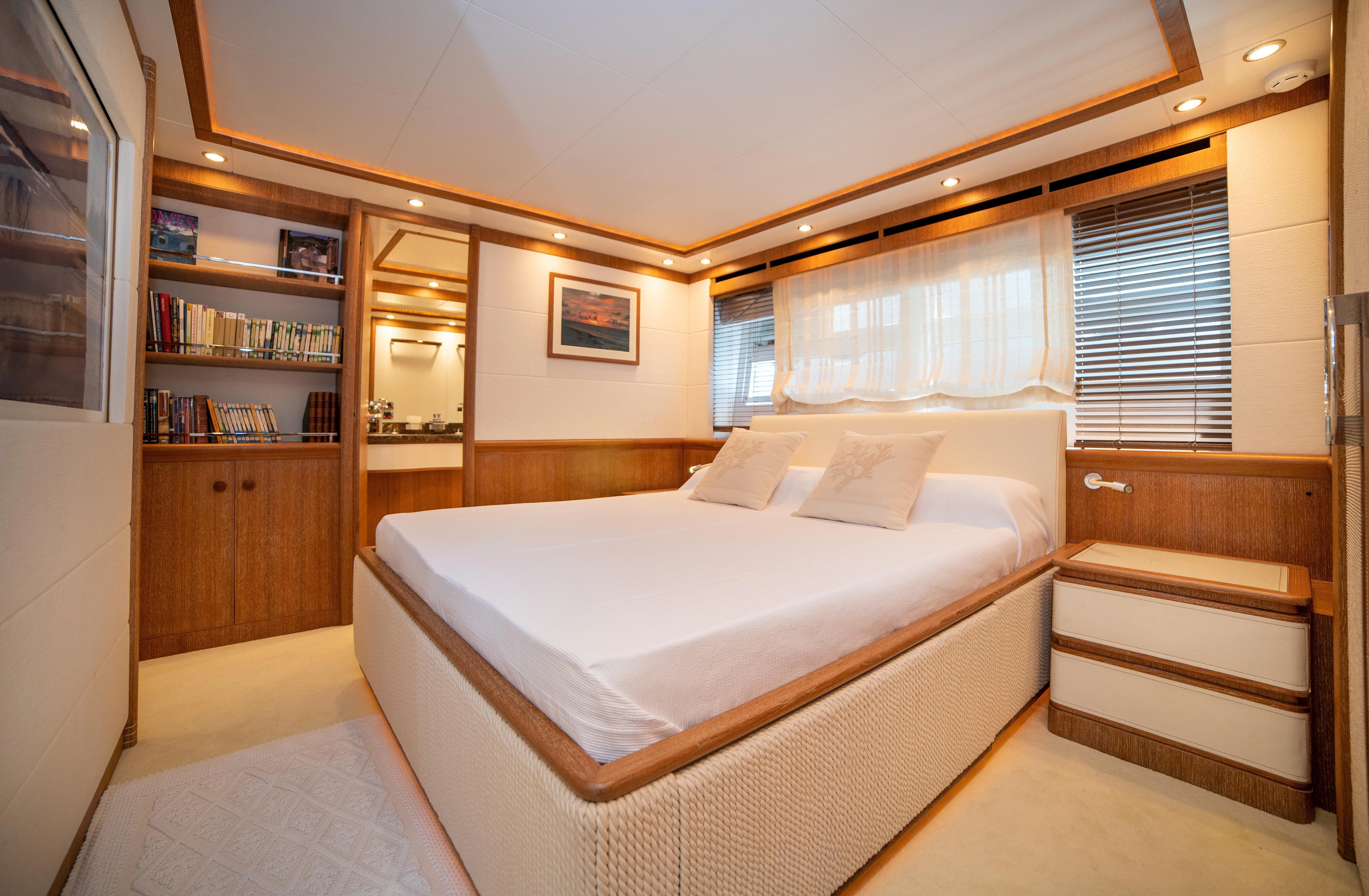 a bedroom with a bed and a bookcase aboard LADY SARYA Yacht for Sale