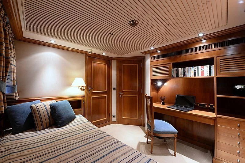 a bedroom with a bed desk and a laptop aboard LADY SARYA Yacht for Sale