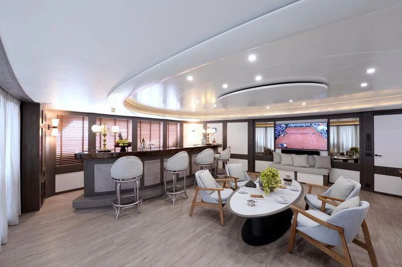 a large room with a bar and chairs aboard LADY SARYA Yacht for Sale