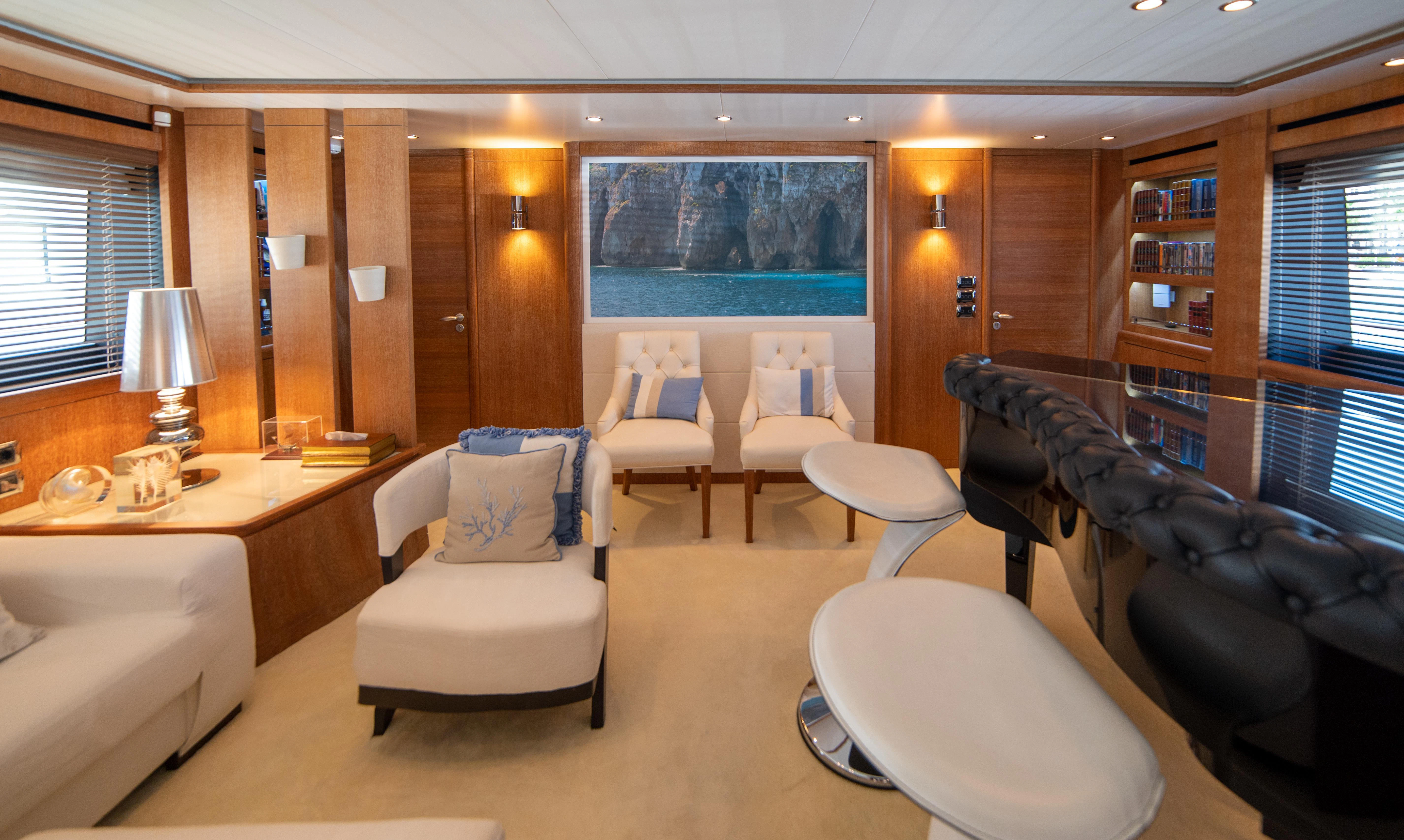 a living room with a large book shelf and a couch aboard LADY SARYA Yacht for Sale